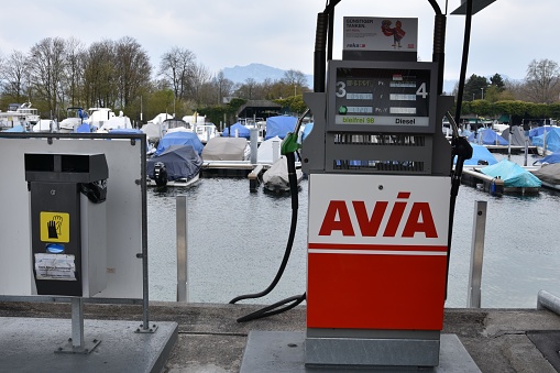 Lucerne, Switzerland 04 17 2021:  Front view on fuel filling station from Avia company in marina harbor of city of Lucerne situated on Lake Lucerne with moored yachts and motor boats in background.