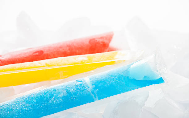 Frozen Ice Pops Frozen fruit flavored ice pops on ice. A summer time treat! flavored ice stock pictures, royalty-free photos & images