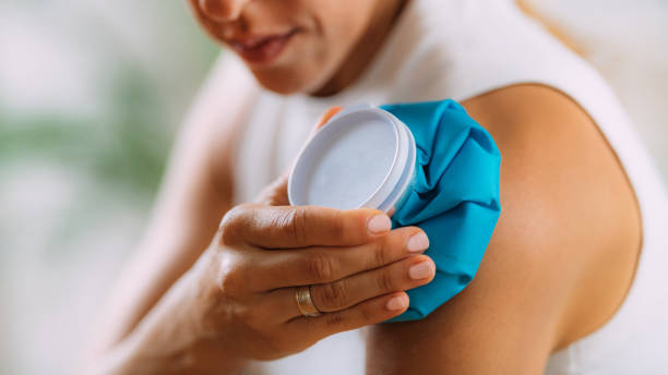 Frozen Shoulder. Woman Holding Cold Compress, Ice Bag Pack on her Painful Shoulder stock photo