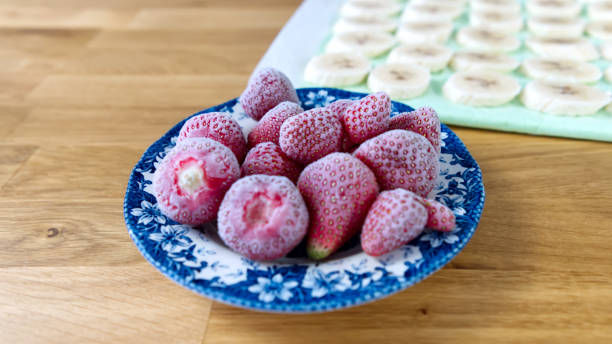 Frozen strawberries and banana on the wooden table Frozen strawberries and banana on the wooden table. ready to making dessert. defrost stock pictures, royalty-free photos & images