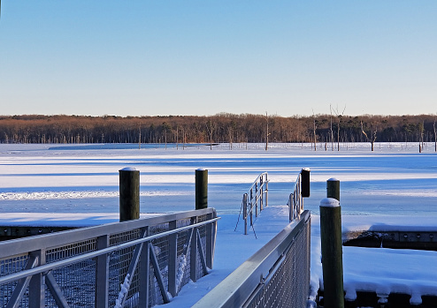 Ramp leading to the partially frozen waters of Manasquan Reservoir, in Howell, New Jersey, after a snow storm