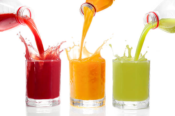 Fruit juices poured from bottles Kiwi, currants, orange stock photo