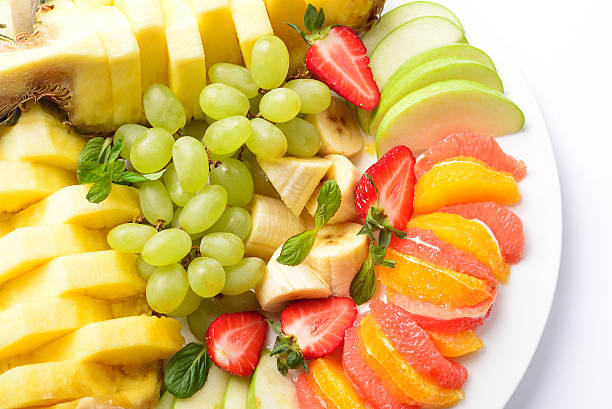fruit plate, isolated. Banana, pineapple, strawberry, grape stock photo