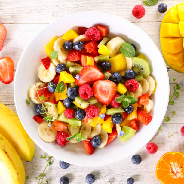 fruit salad with banana, mango and berry fruit fruit salad with banana, mango and berry fruit fruit salad stock pictures, royalty-free photos & images