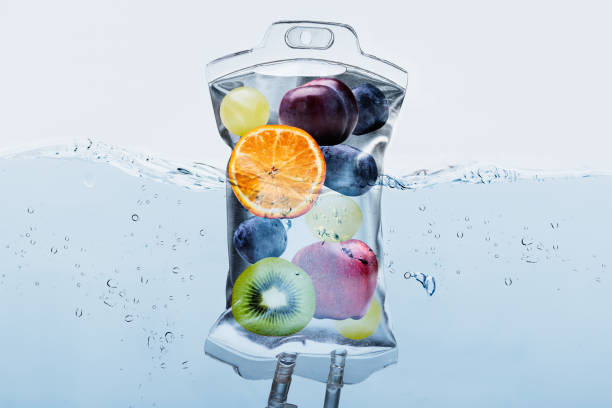 фруктовые ломтики в солевой мешок, смоченной в воде на фоне - капельница для внутривенного вливания стоковые фото и изображения