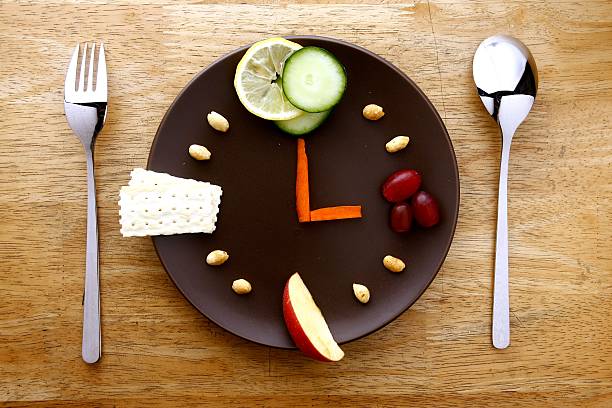 Fruits and vegetables on a plate arranged like a clock stock photo