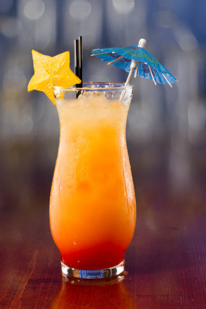 fruity cocktail fresh tropical juices mixed and served in a glass decorated with a carambola slice a parasol screwdriver drink stock pictures, royalty-free photos & images