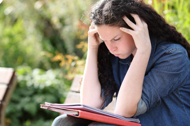 Frustrated student trying to understand lesson in a park Frustrated student trying to understand lesson in a park toughest exams stock pictures, royalty-free photos & images