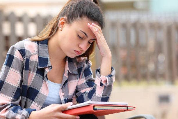 Frustrated student trying to understand lesson in a park Frustrated student trying to understand lesson in a park hardest exams stock pictures, royalty-free photos & images