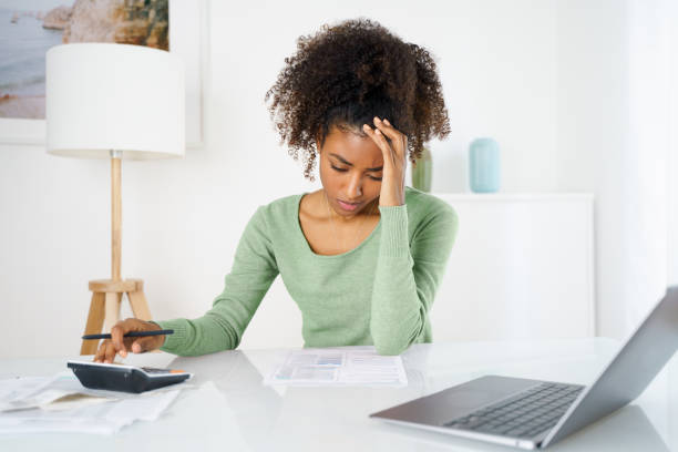 Frustrated young woman with laptop working in home office Unhappy black woman feel stressed working on computer at home student debt stock pictures, royalty-free photos & images