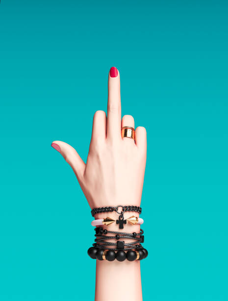 Fuck you hand sign. Bad girl gesture with gold wrist bracelets and finger rings isolated, creative art protest banner, fashion hipster accessories, 3d rendering Fuck you hand sign. Bad girl gesture with gold wrist bracelets and finger rings isolated, creative art protest banner, fashion hipster accessories, 3d rendering gold ring on finger stock pictures, royalty-free photos & images