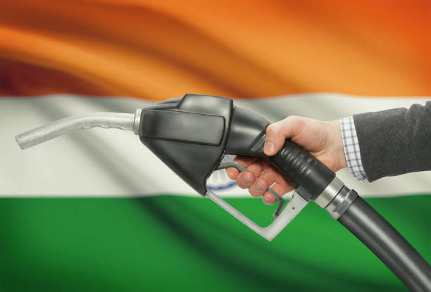Fuel pump nozzle in hand with national flag on background - India Fuel pump nozzle in hand with flag on background - India oil  stock pictures, royalty-free photos & images