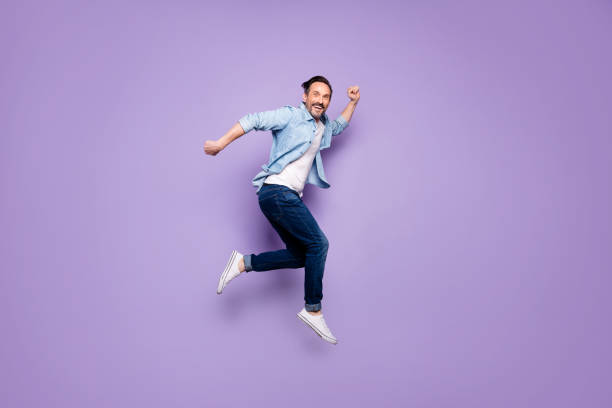 Full body profile side photo of crazy cheerful man jump have rest relax run after spring time sales discounts wear good looking clothing isolated over violet color background Full body profile side photo of crazy cheerful man jump have rest, relax run after spring time sales discounts wear good looking clothing isolated over violet color background jumping stock pictures, royalty-free photos & images