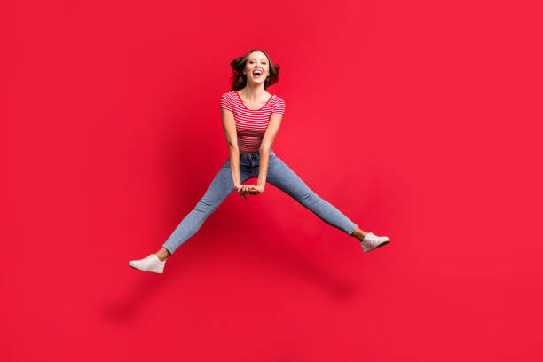 Full length body size photo of beautiful cute pretty sweet lovely girl jumping and doing splits in air while isolated over red background Full length body size photo of beautiful cute pretty sweet lovely girl jumping and doing, splits in air while isolated over red background doing the splits stock pictures, royalty-free photos & images
