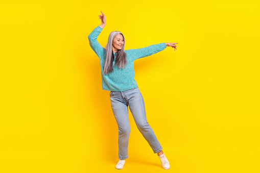 Full length body size view of attractive cheerful carefree woman dancing isolated on bright yellow color background.