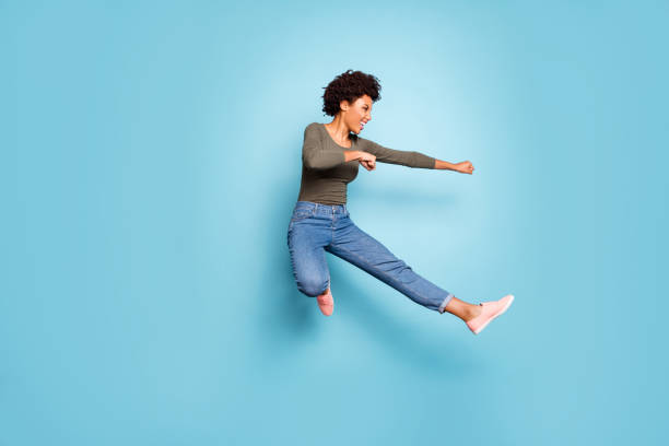 Full length photo of dark skin wavy lady jumping high dancing modern youngster moves practicing judo fighting wear casual outfit isolated pastel blue color background Full length photo of dark skin wavy lady jumping high dancing modern, youngster moves practicing judo fighting wear casual outfit isolated pastel blue color background warrior person stock pictures, royalty-free photos & images