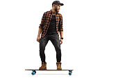 istock Full length shot of a guy standing on a longboard 1370477646
