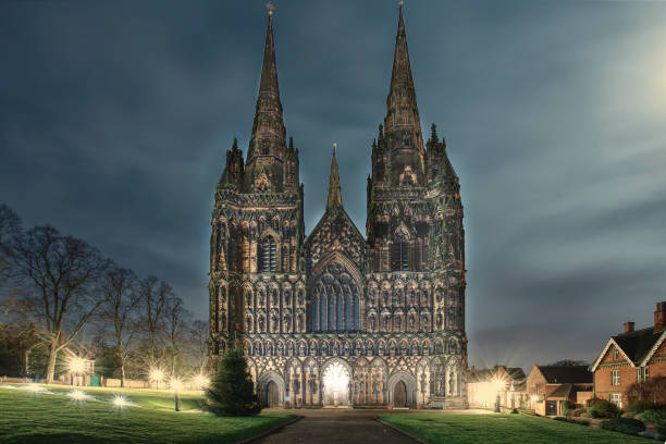 Full moon over Lichfield Cathedral building-famous historic landmark at night. stock photo