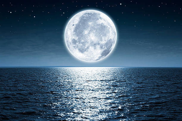 Full moon Full moon rising over empty ocean at night with copy space seascape stock pictures, royalty-free photos & images