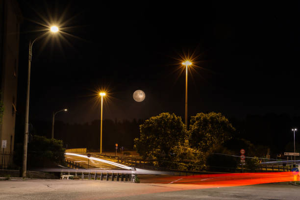Full moon rising over a road (Italy) stock photo