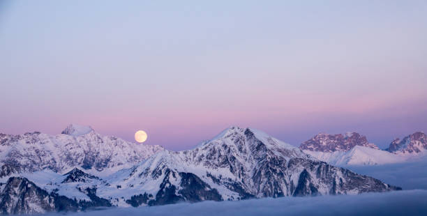 lua cheia erguendo-se sobre uma paisagem de sonho de inverno - davos - fotografias e filmes do acervo