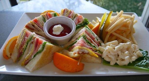 Full serving of a Club Sandwich with catsup and mayonnaise dip stock photo