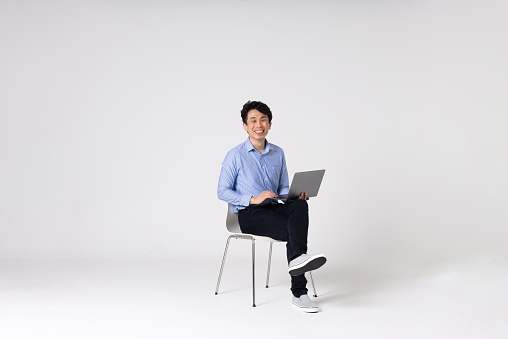 Full-length portrait of an Asian man on a white background.
Full body shot. Japanese male, 30s.
Healthy and confident figure.
sitting on a chair.