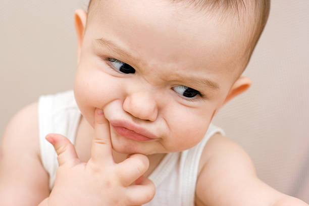 Fun caucasian baby with finger stock photo