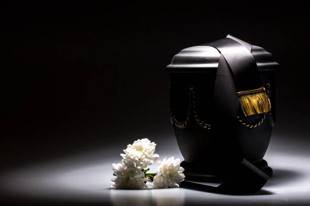 funeral mourning urn, with black tape and white chrysanthemum funeral urn, with tape and flower decorated, for sympathy, card funerary urn stock pictures, royalty-free photos & images