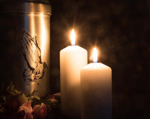 Funeral mourning urn with burning candles for obituary. stock photo