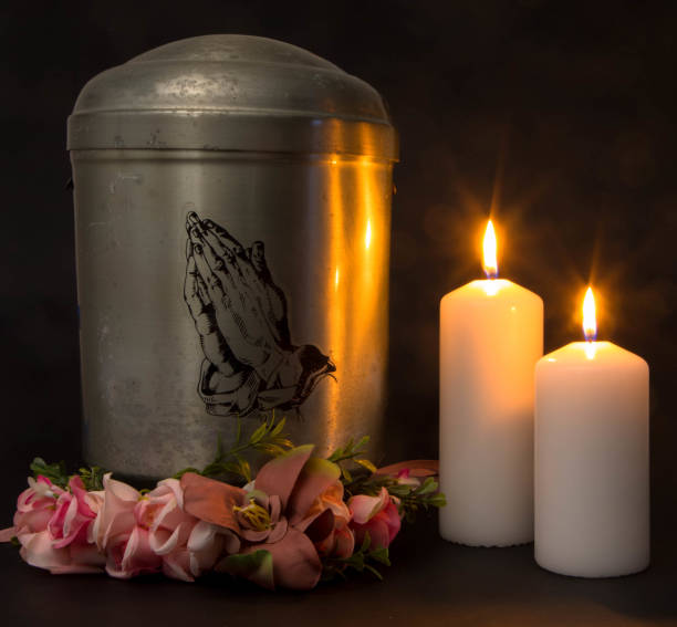 Funeral mourning urn with burning candles for obituary. stock photo
