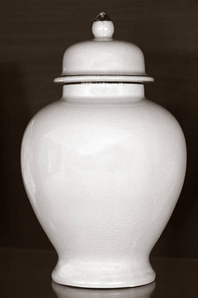 Funeral urn White funeral urn jar shape complete view isolated on dark wooden background.Philosophical concept photo of life ,death, cremation, reincarnation, spiritual , religious , soul ,spirit and spirality funerary urn stock pictures, royalty-free photos & images