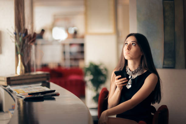 rolig uttråkad kvinna håller smartphone väntar hennes datum - boring date bildbanksfoton och bilder