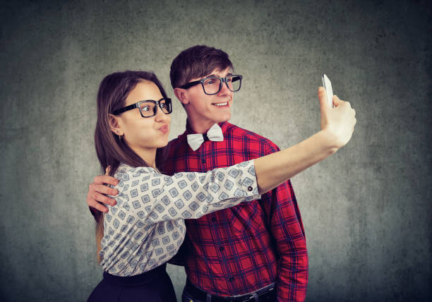 Funny couple making faces taking a selfie on cellphone Funny young couple making faces taking a selfie on cellphone ugly skinny women stock pictures, royalty-free photos & images
