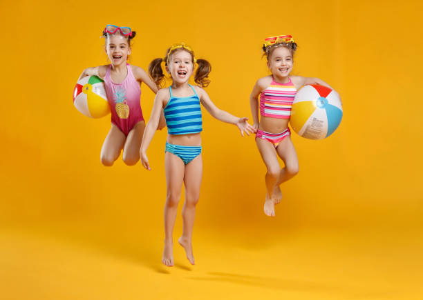 funny funny happy children  jumping in swimsuit  jumping  on colored background funny funny happy children  jumping in swimsuit and swimming glasses jumping on colored background little girls in bathing suits stock pictures, royalty-free photos & images