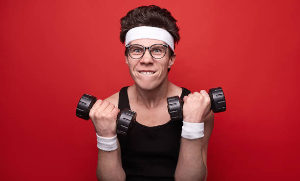 Funny man exercising with dumbbells stock photo