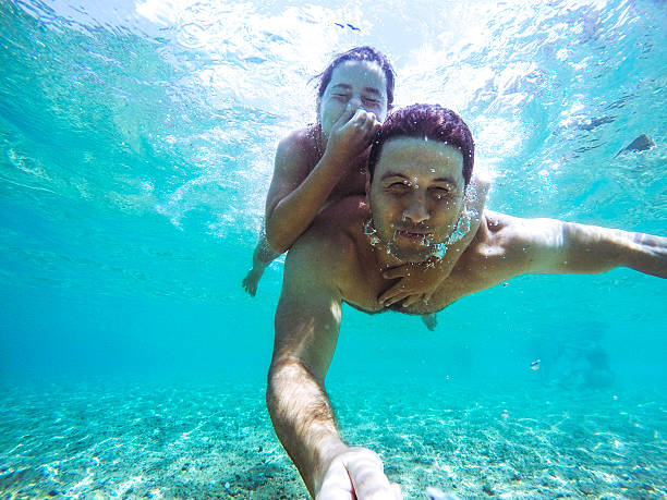 Father and daughter underwater close up portrait on a summer vacation.