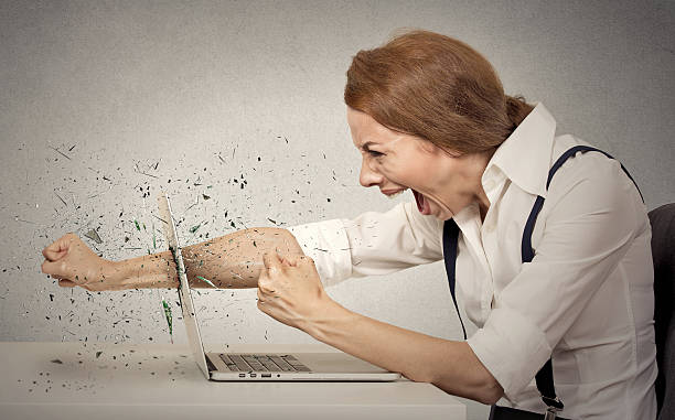 Furious businesswoman throws a punch into computer, screaming Angry, furious businesswoman throws a punch into computer, screaming. Negative human emotions, facial expressions, feelings, aggression, anger management issues destruction stock pictures, royalty-free photos & images