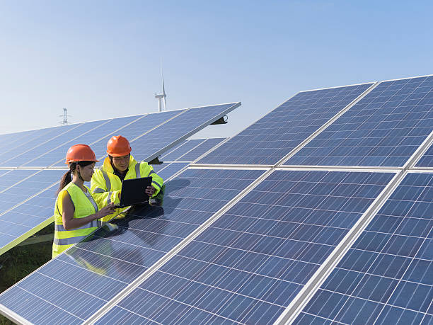Future electrical production, asian engineers workers at a renewable energy plan, young asian engineers  working in  solar power station. solar energy photos stock pictures, royalty-free photos & images