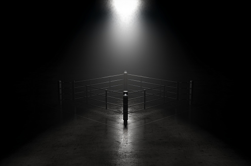 A concept showing a boxing ring on a reflective concrete lined floor backlit by a single honeycomb spotlight - 3D render