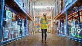 istock Futuristic Technology Retail Warehouse: Worker Doing Inventory Walks when Digitalization Process Analyzes Goods, Cardboard Boxes, Products with Delivery Infographics in Logistics, Distribution Center 1349338716