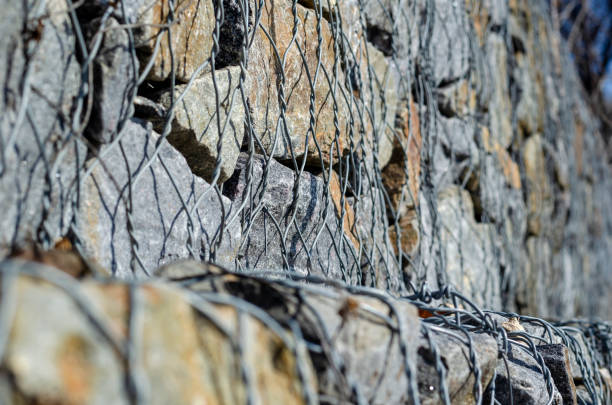 Gabion. Stone fence in a metal mesh. Gabion. Stone fence in a metal mesh. Crushed stone packed in wire mesh. Granite texture. Selective focus. Abstract background. erosion control stock pictures, royalty-free photos & images