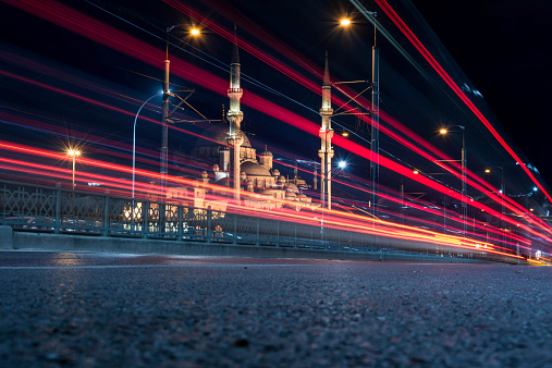 Galata Bridgew with traffic and illuminated Yeni Cami mosque in back.
