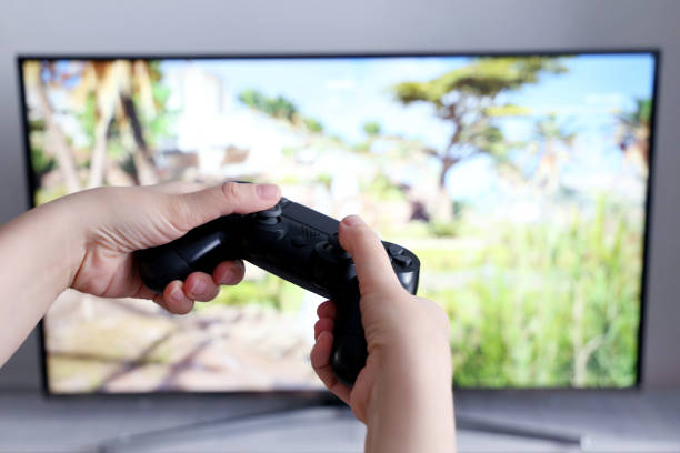 gamepad in female hands closeup on tv screen background, gaming addiction concept - resolução 4k imagens e fotografias de stock