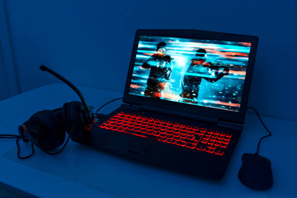 Gaming laptop with connected mouse and headphones stock photo