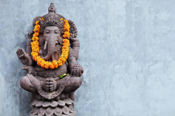 Ganesha sitting in meditating yoga pose in hindu temple. stock photo