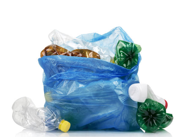 Garbage bag full of plastic waste, eggplants and bottles isolated on white stock photo