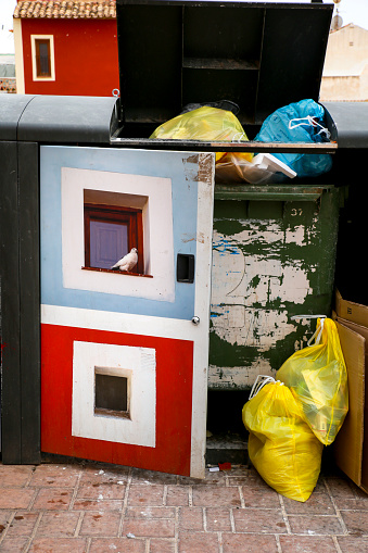 Villajoyosa, Alicante, Spain- April 22, 2022: Garbage container with beautiful paintings on the street