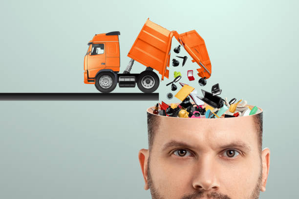 Garbage in the head, clogging up the head with unnecessary information. Garbage truck unloads garbage into the head. stock photo