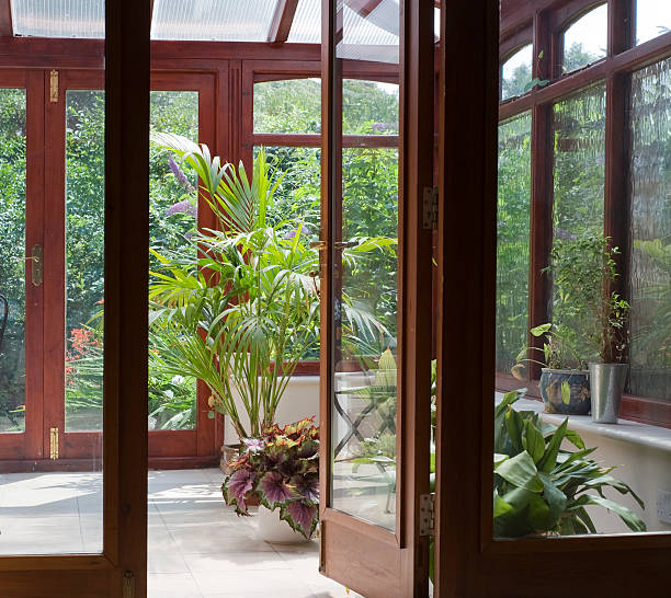 Garden bohemian room filled with plants conservatory tables chairs plants room in house next to garden greenhouse table stock pictures, royalty-free photos & images